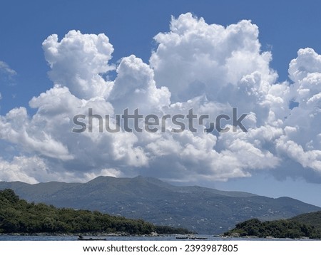 A beautiful gradient of blue and white in the summer sky, with soft and fluffy clouds and a gentle breeze.