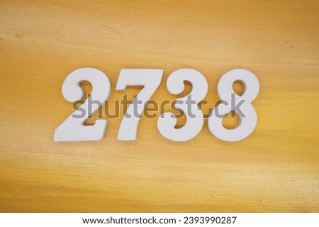 The golden yellow painted wood panel for the background, number 2738, is made from white painted wood. Royalty-Free Stock Photo #2393990287