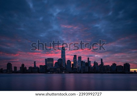 Night atmosphere with red pre-sunrise clouds above Lower Manhattan cityscape. New York panorama as captured from New Jersey. Royalty-Free Stock Photo #2393992727