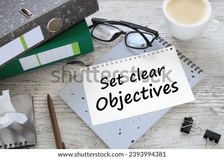 two office folder gray notepad. text on the page SET CLEAR OBJECTIVES