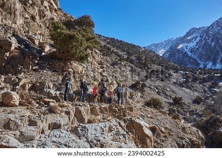A group of tourists trekking through the stunning Atlas Mountains in Morocco, embracing the beauty of the rugged terrain and connecting with nature