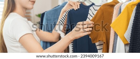 Choice of clothes,Nothing to wear. Attractive asian young woman, girl try on appare, happy choosing dress, outfit on hanger in wardrobe in room closet at home. Deciding blouse what to put on which one