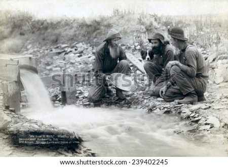 Three men, with dog, panning for gold in a stream in the Black Hills of South Dakota in 1889. Old timers, Spriggs, Lamb and Dillon may be die hard survivors from the Gold Rush of 1876. Royalty-Free Stock Photo #239402245