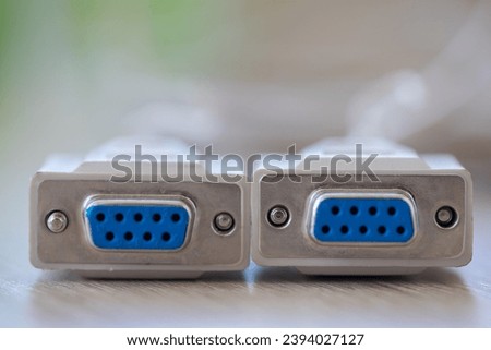 Close-up of a RS-232 serial port. Female to female extension cord on a wooden table. Royalty-Free Stock Photo #2394027127