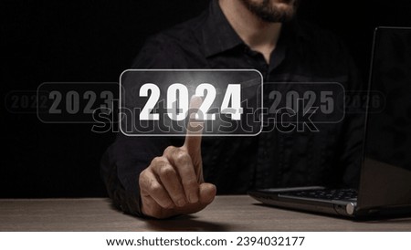 The beginning of the new year 2024. A man's hand chooses 2024, planning and strategy for tasks in the new year