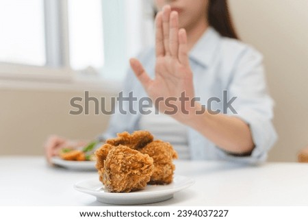 Diet food loss weight concept, Hand of woman pushing fast food away and avoid to eat fried chicken to control cholesterol and sugar. Royalty-Free Stock Photo #2394037227
