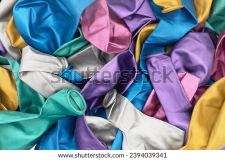 Top view of colorful deflated balloons texture background. Pile of multiple colorful unblown balloons pattern. Heap of colorful deflated balloons Royalty-Free Stock Photo #2394039341