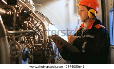 Industrial worker inspects turbine pre-engine start in industrial setting. Showcases industrial workers focus on safety, efficiency. Ideal for highlighting an industrial workers expertise.
