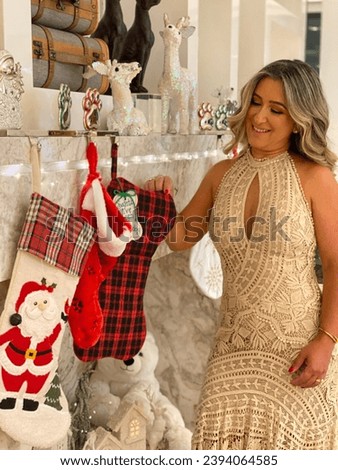 Christmas happy golden woman beautiful smiling gentle red fireplace decoration sock gifts girl happiness brushed hair curly makeup dress lace living room marble white bear