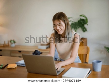 Creative designer woman using laptop to checking photo and working graphic design in home studio.
