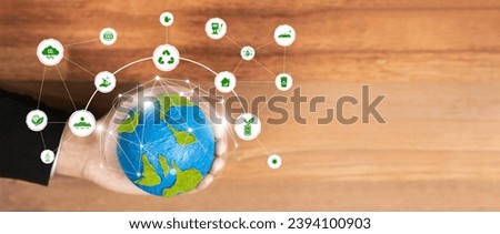 Businessman's hand holding Earth globe symbolize corporate commitment to ESG or CSR to reduce carbon emission and adopting eco-friendly clean business to minimize environmental impact. Pano Reliance Royalty-Free Stock Photo #2394100903
