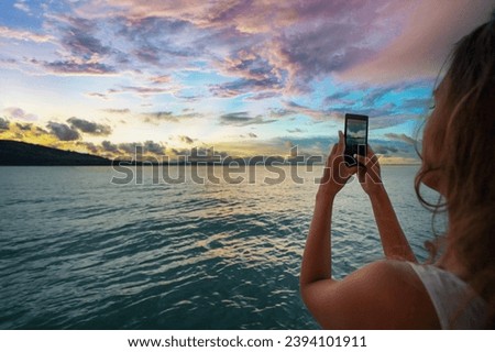 Travel lifestyle. Young woman taking photo of beautiful sea lagoon on smartphone.