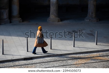 Belgrade, Serbia - December 02, 2020: One young woman  walking by dark abandoned alley, alone, high angle view Royalty-Free Stock Photo #2394105073