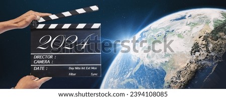 The year 2024, Hand-holding clapperboard or movie slate in video production and film industry.Storytelling of sci-fi, science and technology, global, and universe concepts. element of images furnished