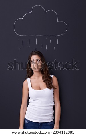 Thinking, sad and rain cloud with woman on a chalkboard for drawing, emotion or expression in studio. Depression, idea or weather and an unhappy young person with a chalk picture of a winter storm