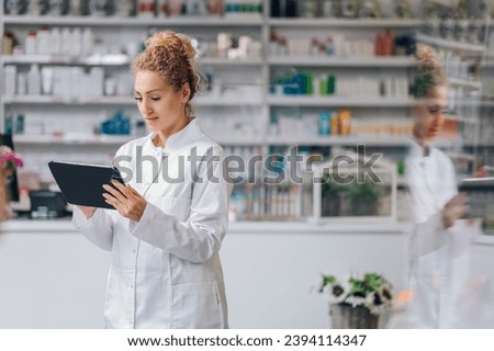 A picture of a young Caucasian female pharmacist holding a tablet, doing inventory and preparing to order a new batch of medication. Curly hair, curious, focused. Blurry reflection in the counter.