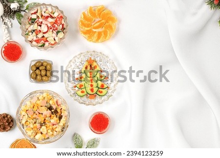 Christmas New Year dishes, traditional Olivier salad, vegetable salad of cucumbers, tomatoes and radishes and a variety of vegetable snacks, holiday serving concept, selective focus