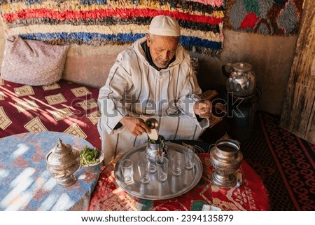 Man in traditional clothes preparing Moroccan tea in cup Royalty-Free Stock Photo #2394135879