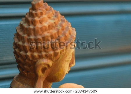 Close-up of a brown head statue buddhist character. Side photo on dark background with lines with perspective, maybe Buddha.