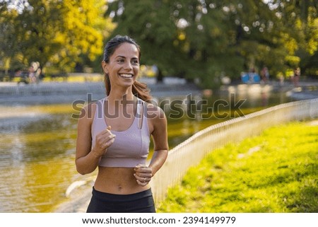 Young woman jogging outdoors. Concept of healthy lifestyle. Happy female runner jogging in the morning in nature. Sports training. Young woman running against morning sun