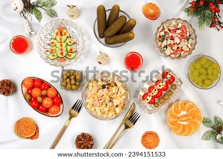 Christmas New Year dishes, traditional Olivier salad, vegetable salad of cucumbers, tomatoes and radishes and a variety of vegetable snacks, holiday serving concept, selective focus