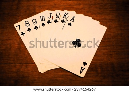 Full black clubs street, close-up of poker cards on a warm brown table