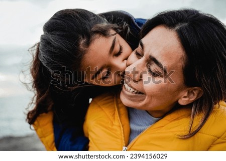 Mother and daughter having tender moment outdoor in winter day. Latin family and love concept