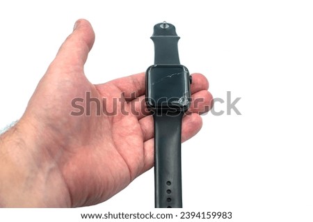 Smart watch with a broken screen in hand on a white background.