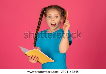 Great Idea. Excited Preteen Girl Holding Notepad And Raising Pencil Up, Clever Little Female Child Ready To Answer A Question, Having Inspiration, Standing On Pink Studio Background, Copy Space