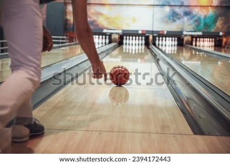 Cropped image of a man throwing a red bowling ball