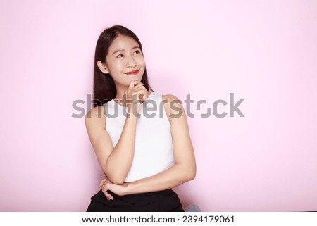 The young woman was thinking, Portrait of a beautiful young woman in a light pink background, half body photo of nice positive lady.