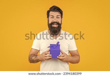 amazed man with present box in studio. man with present box on background.