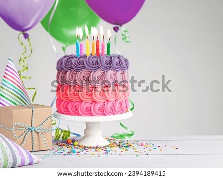 Colorfull Rose Birthday cake, presents, hats and colorful balloons over light grey Background.