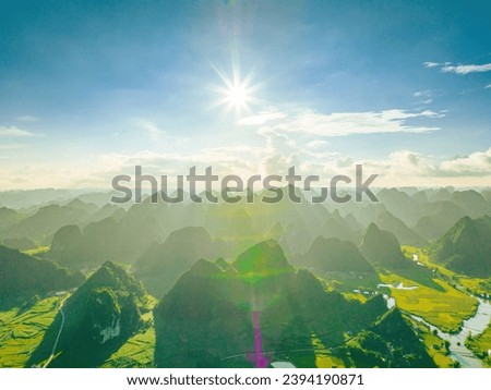 Aerial view landscape in Phong Nam valley in cinematic sunset, an extreme scenery landscape at Cao bang province, Vietnam with river, nature, green rice fields. Travel and landscape concept.