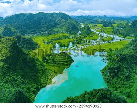 Aerial landscape in Quay Son river, Trung Khanh, Cao Bang, Vietnam with nature, green rice fields and rustic indigenous houses. Near Ban Gioc Waterfall. Travel and landscape concept. Royalty-Free Stock Photo #2394190923