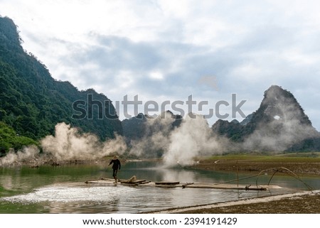 View of fishermen casting his net on river in Thung mountain in Tra Linh, Cao Bang province, Vietnam with lake, cloudy, nature and camping outdoor. Travel and landscape concept.