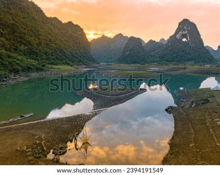 Aerial view of Thung mountain cinematic sunset background in Tra Linh, Cao Bang province, Vietnam with lake, cloudy, nature, camping and fisherman. Travel and landscape concept.
