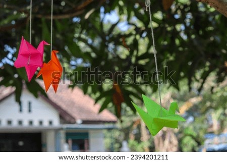 Hanging elegance in the form of origami cranes, dancing delicately from the branches.