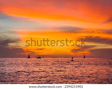 Sunset in Florida Keys with bright colors and silhouetted sailboats.