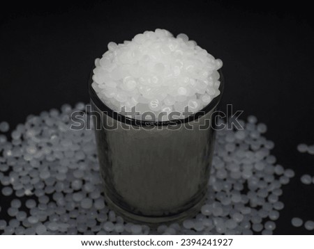 High density polyethylene plastic granules on a black background, this virgin polymer is one of the basic materials in the plastics industry Royalty-Free Stock Photo #2394241927