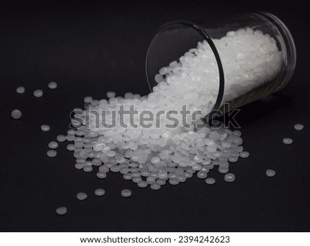 High density polyethylene plastic granules on a black background, this virgin polymer is one of the basic materials in the plastics industry Royalty-Free Stock Photo #2394242623