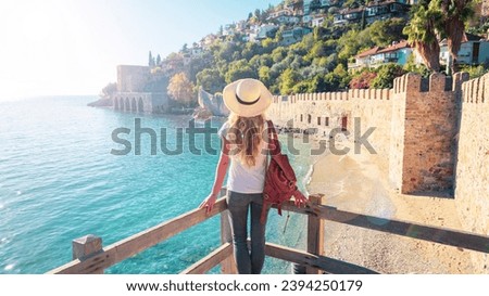Young female tourist looking at Red tower in Alanya, Antalya in Turkey Royalty-Free Stock Photo #2394250179