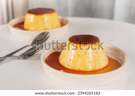 homemade Japanese caramel custard pudding on white  ceramic plate. Royalty-Free Stock Photo #2394265183