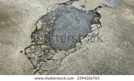 A picture of potholes at damage road, Damaged asphalt pavement road with potholes. Potholes on a road. Damaged road with potholes caused. Hole in the asphalt caused by deterioration of the pavement.