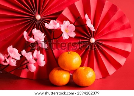Chinese New Year of the dragon festival concept. Mandarin orange, red envelopes and gold ingot with red paper fans. Traditional holiday lunar New Year. 