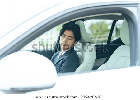 A driver sleeping inside a car.  self-driving. break. Sleeping in the car. Royalty-Free Stock Photo #2394286301