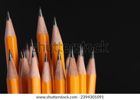 Many graphite pencils on black background, macro view. Space for text