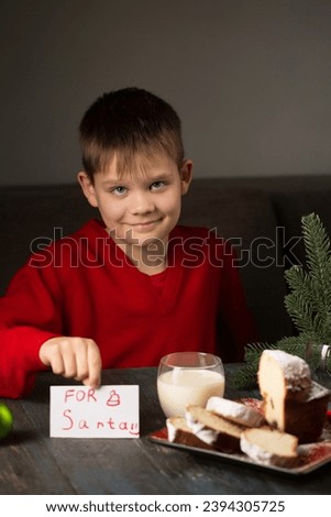 A little boy writes a note to Santa and prepares a treat