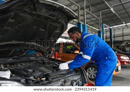Auto mechanic in blue uniform are repair and maintenance auto engine is problems at car repair shop.