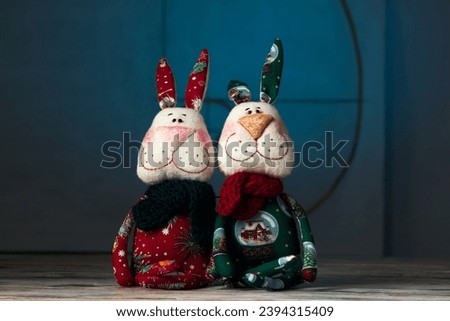 Two tilda New Year's hares handmade toys on a blue background